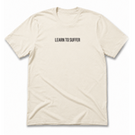 A cream-colored short-sleeve t-shirt with the text 'LEARN TO SUFFER' printed in black sans-serif font across the chest, displayed on a clean white background.