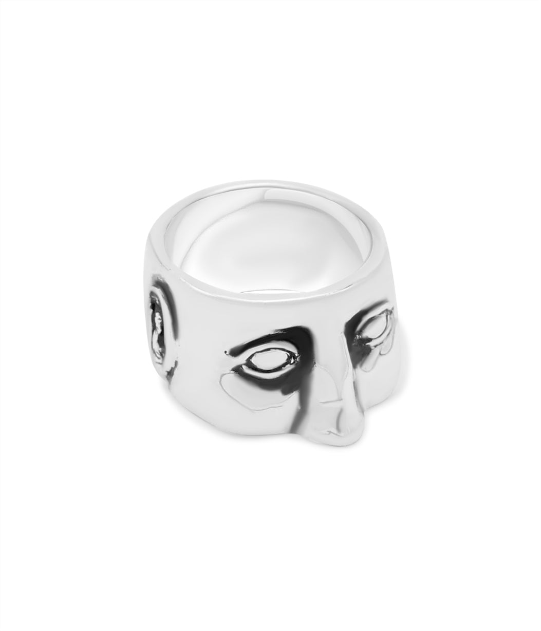 Silver ring with face design on a white background