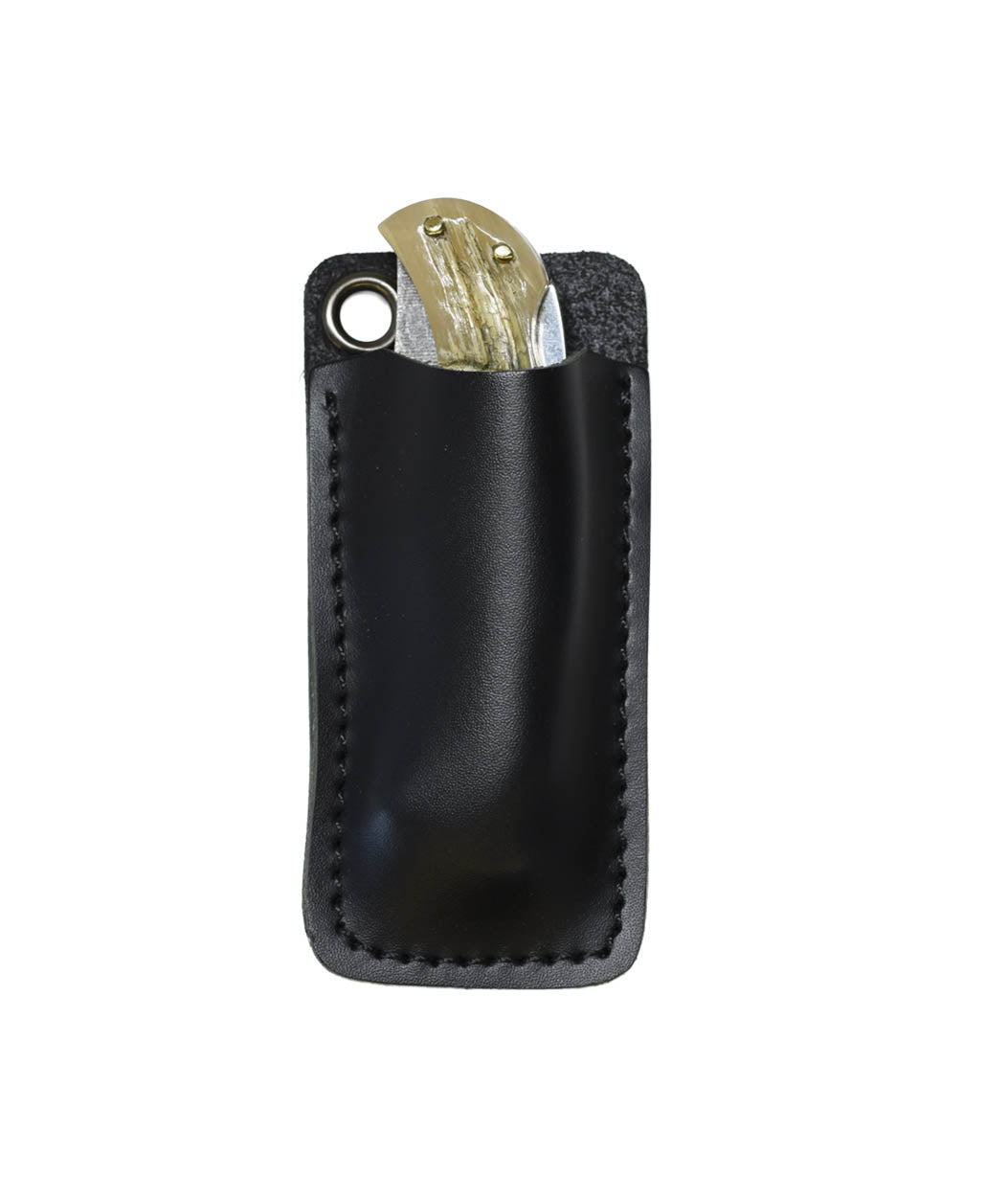 A black leather key pouch with a metal grommet, shown holding a brass key, isolated on a white background.