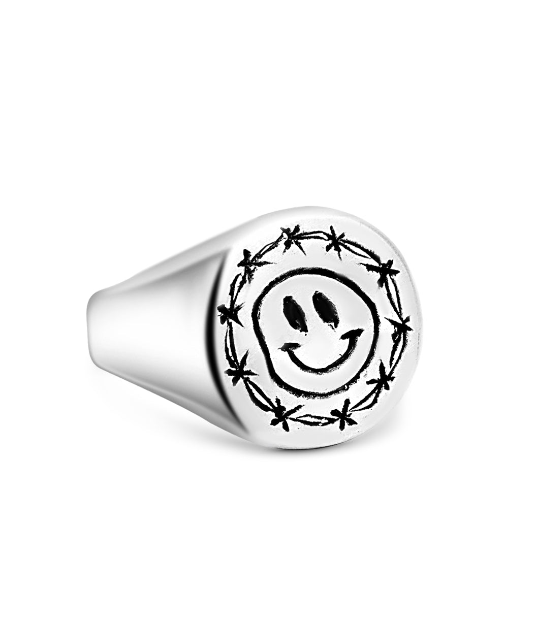 Silver ring with a smiley face design on a white background