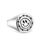 Silver ring with a smiley face design on a white background
