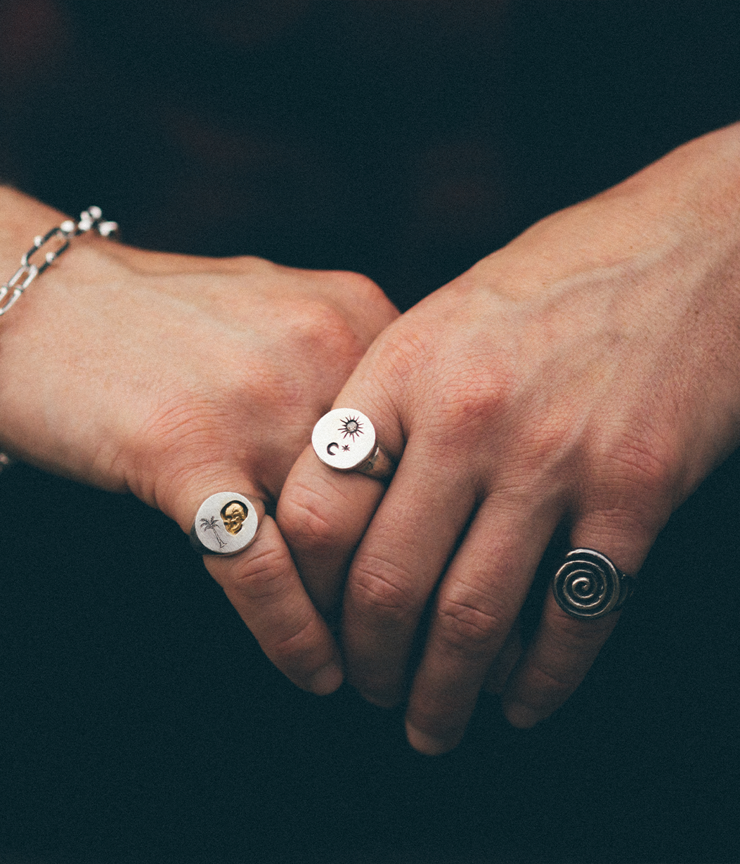 mans hands with multiple silver rings 