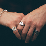 mans hands with multiple silver rings 