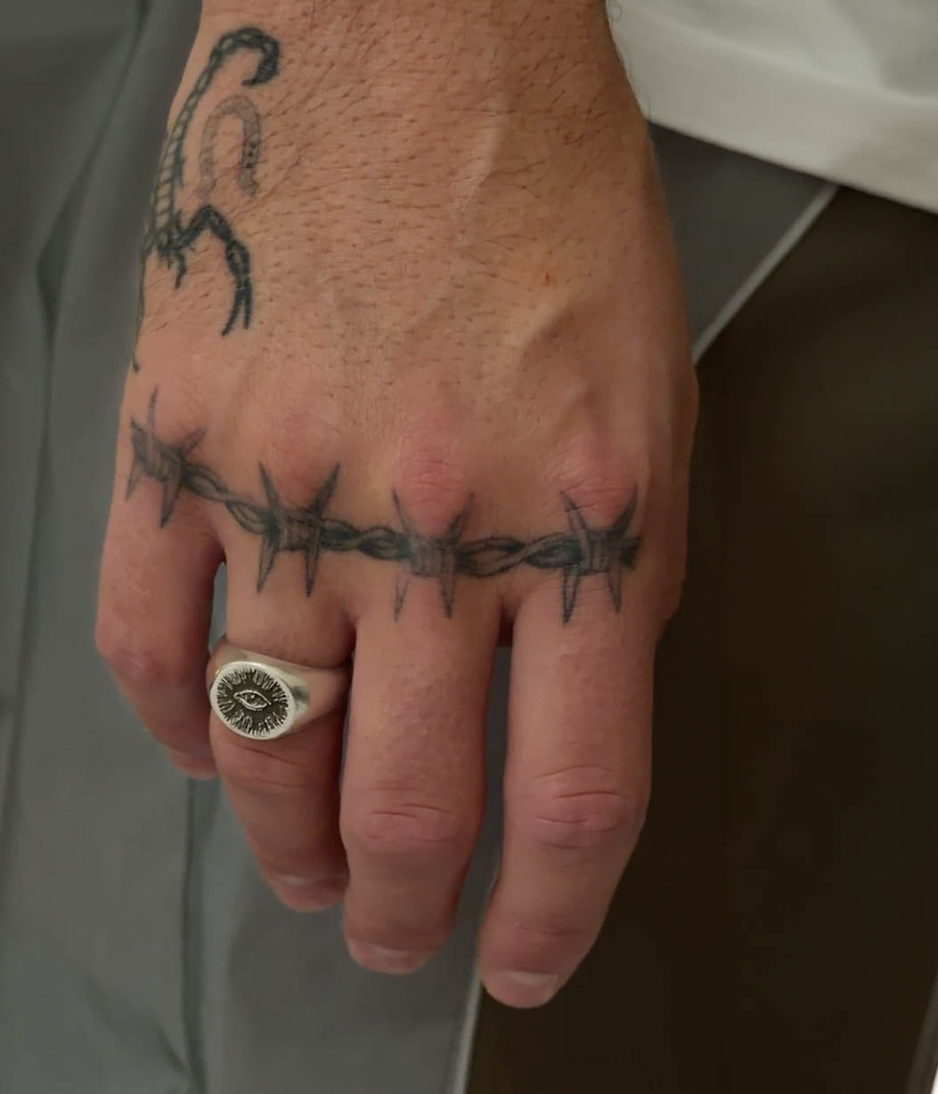eye signet on hand with tattoos