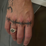 eye signet on hand with tattoos