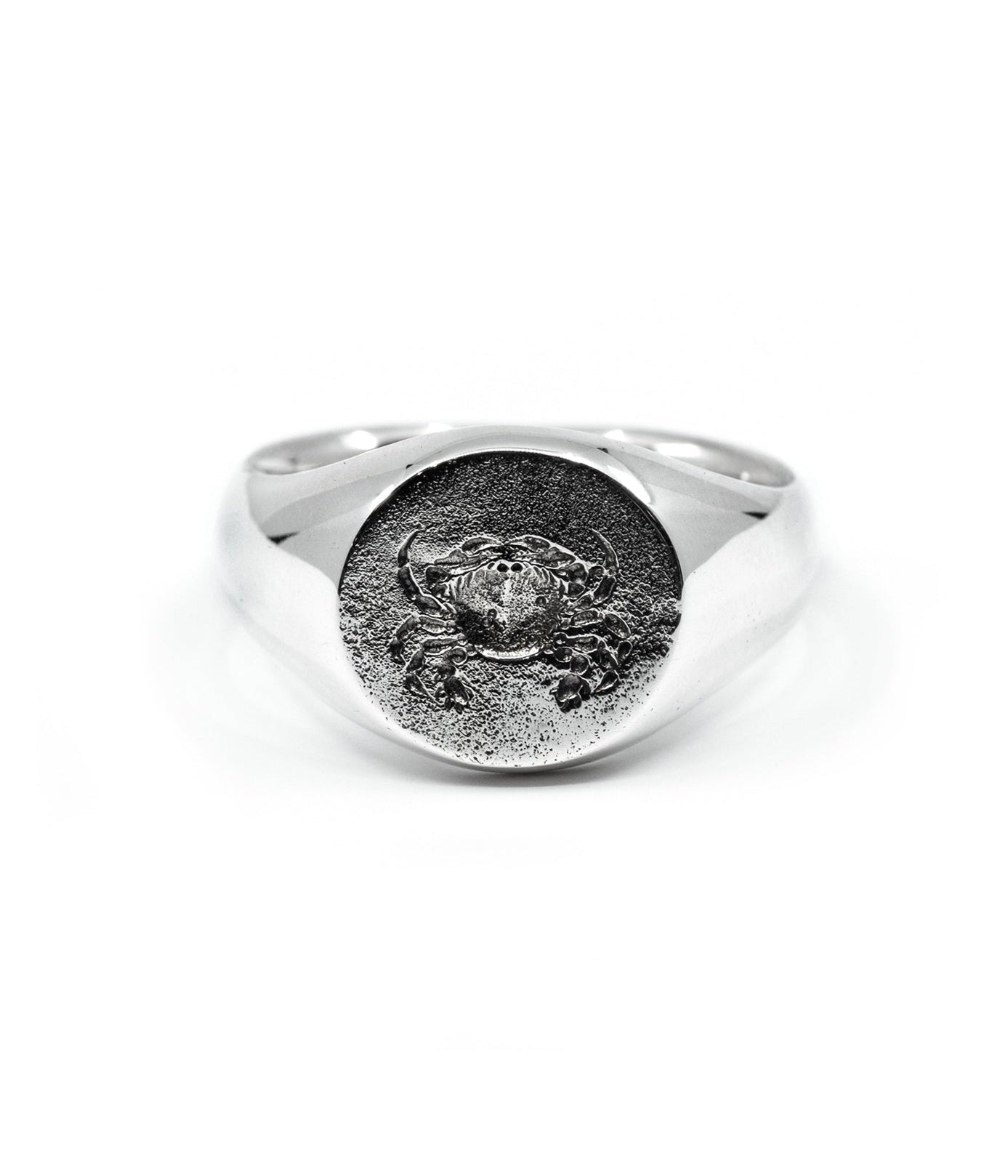 Silver ring with engraved design on a white background