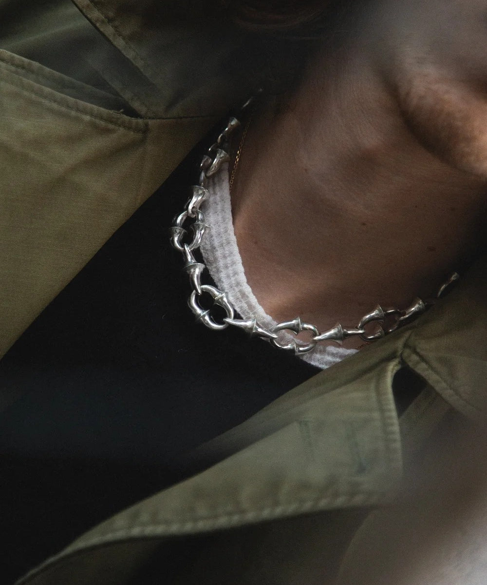 Close-up of a chain detail on a green jacket