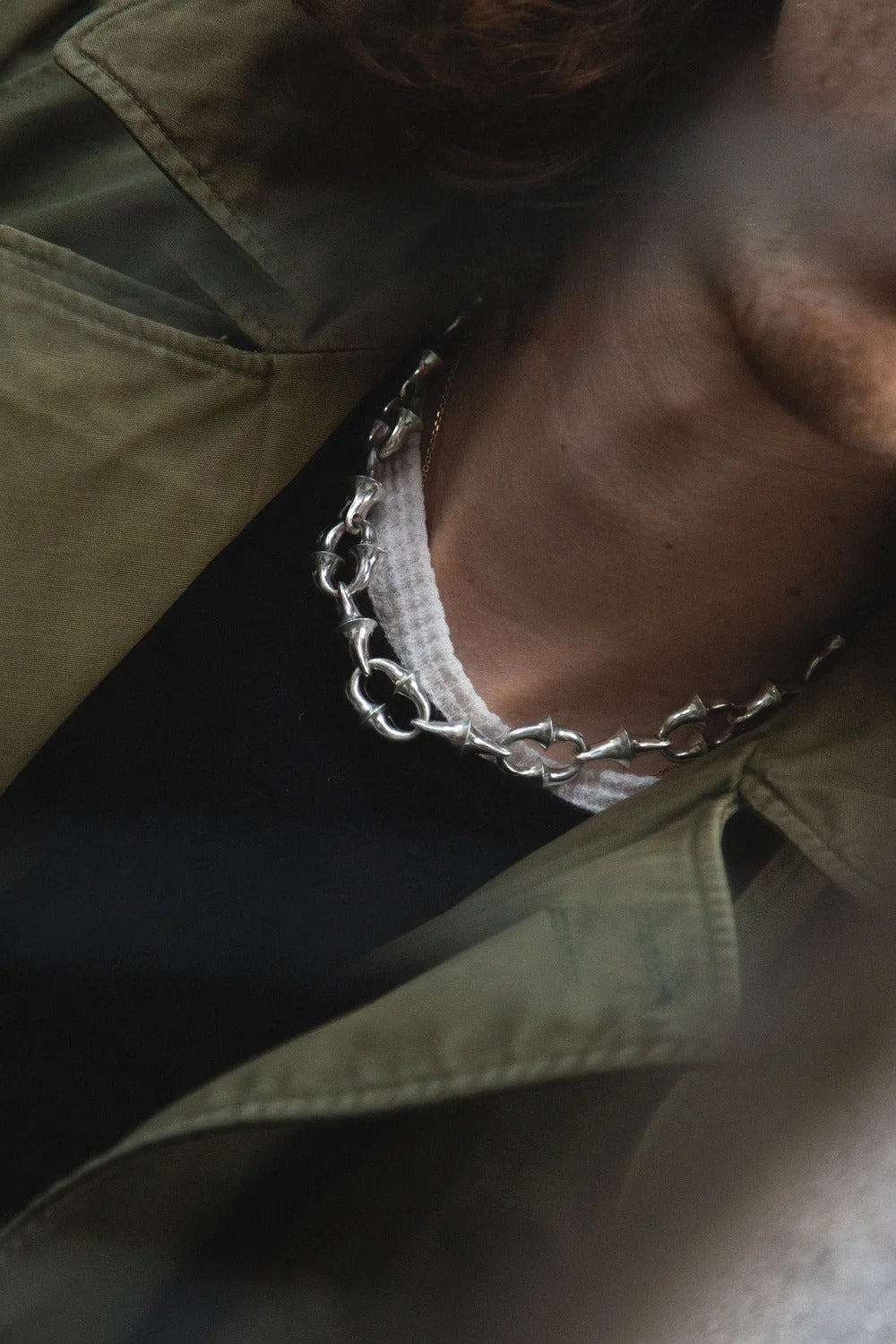 Close-up of a chain detail on a green jacket
