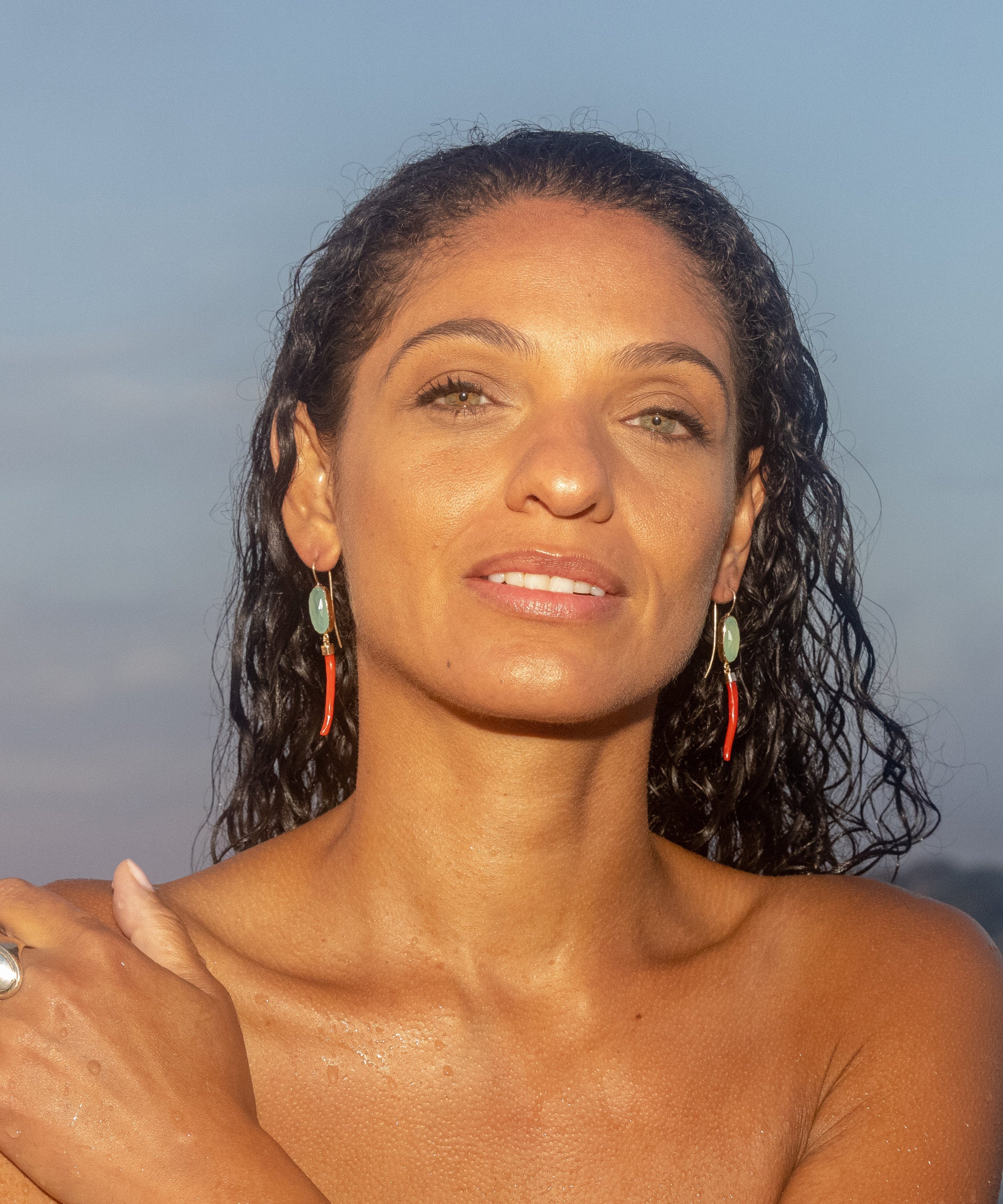 Woman with wet hair standing on a beach at sunset