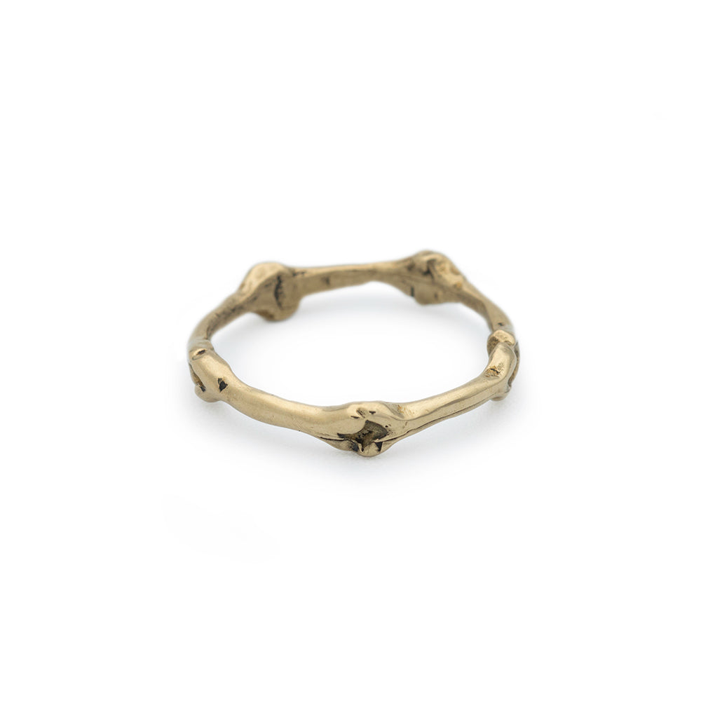 Gold ring with a branch-like design on a white background