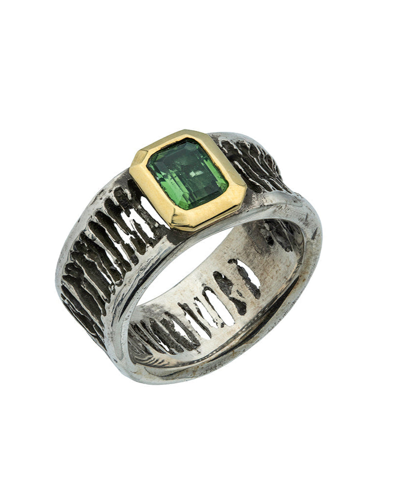 Ring with green gemstone and gold accents on a white background