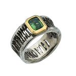 Ring with green gemstone and gold accents on a white background