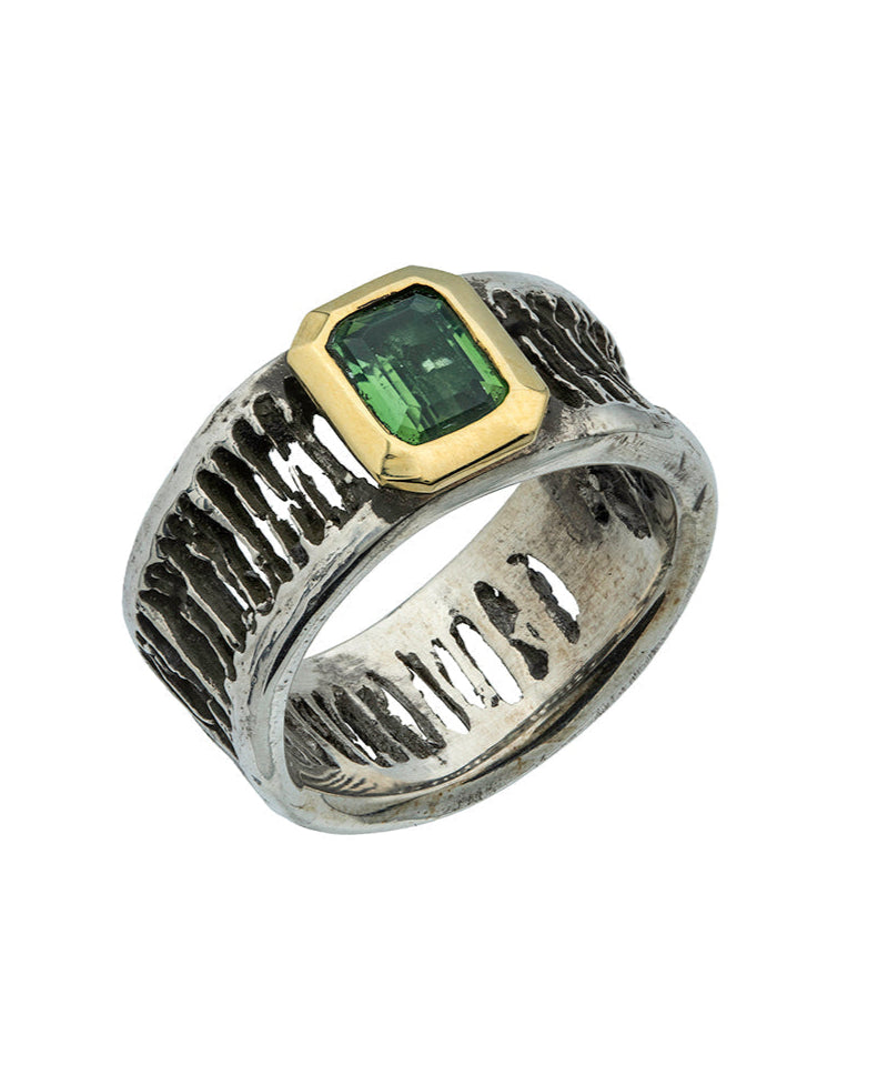 Ring with green gemstone and gold accents on a white background