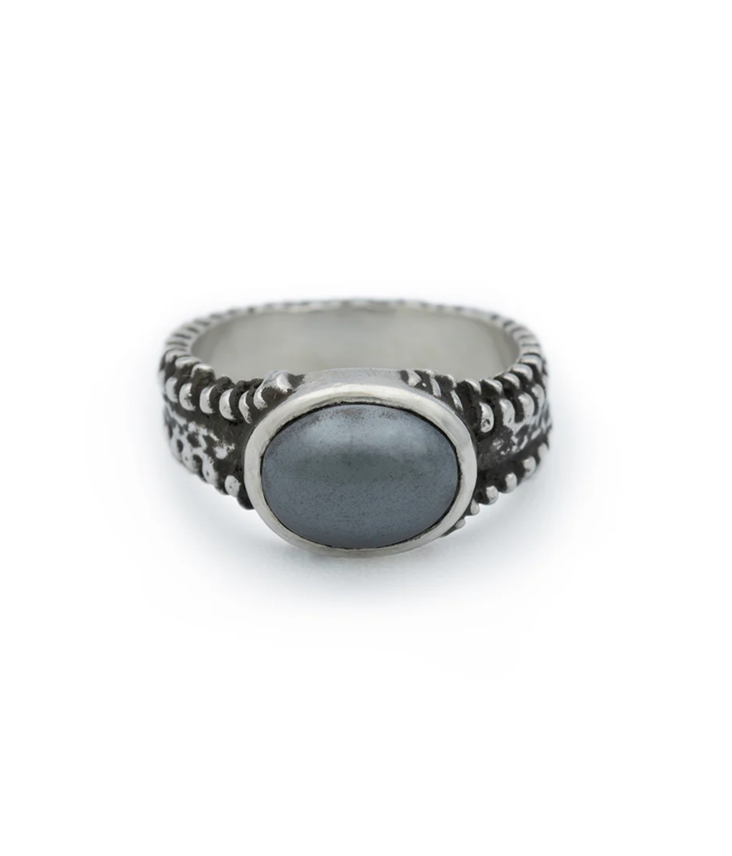 Silver ring with a dark stone on a white background